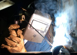040604-N-7408M-001 Atlantic Ocean (June 4, 2004)-- Hull Technician 2nd Class Chris B. Millones of Sacramento, Calif. welds a piece of steel pipe in the pipe fitter's shop. Enterprise is currently underway in support of Summer Pulse 2004. Official U.S. Navy photo by Photographer's Mate Airman Justin McGarry. Image released by LT K. R. Stephens, PAO, CVN 65.